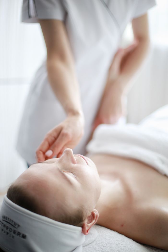 Woman receiving a calming massage therapy session at a spa with focus on relaxation.
